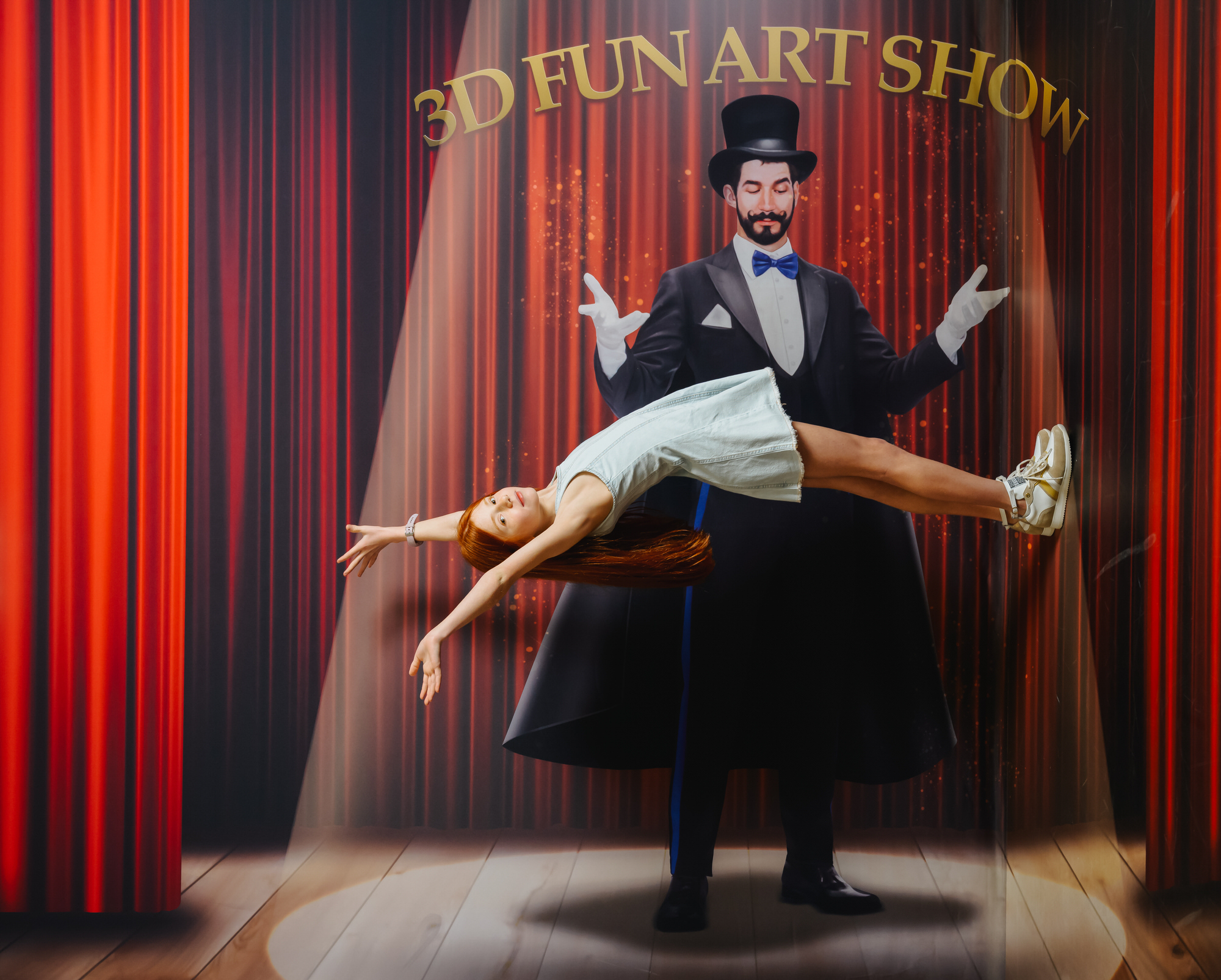 Young girl levitating in front of a magician at a "3D Fun Art Show", wearing GIGAshoes white and gold sneakers and a denim dress.